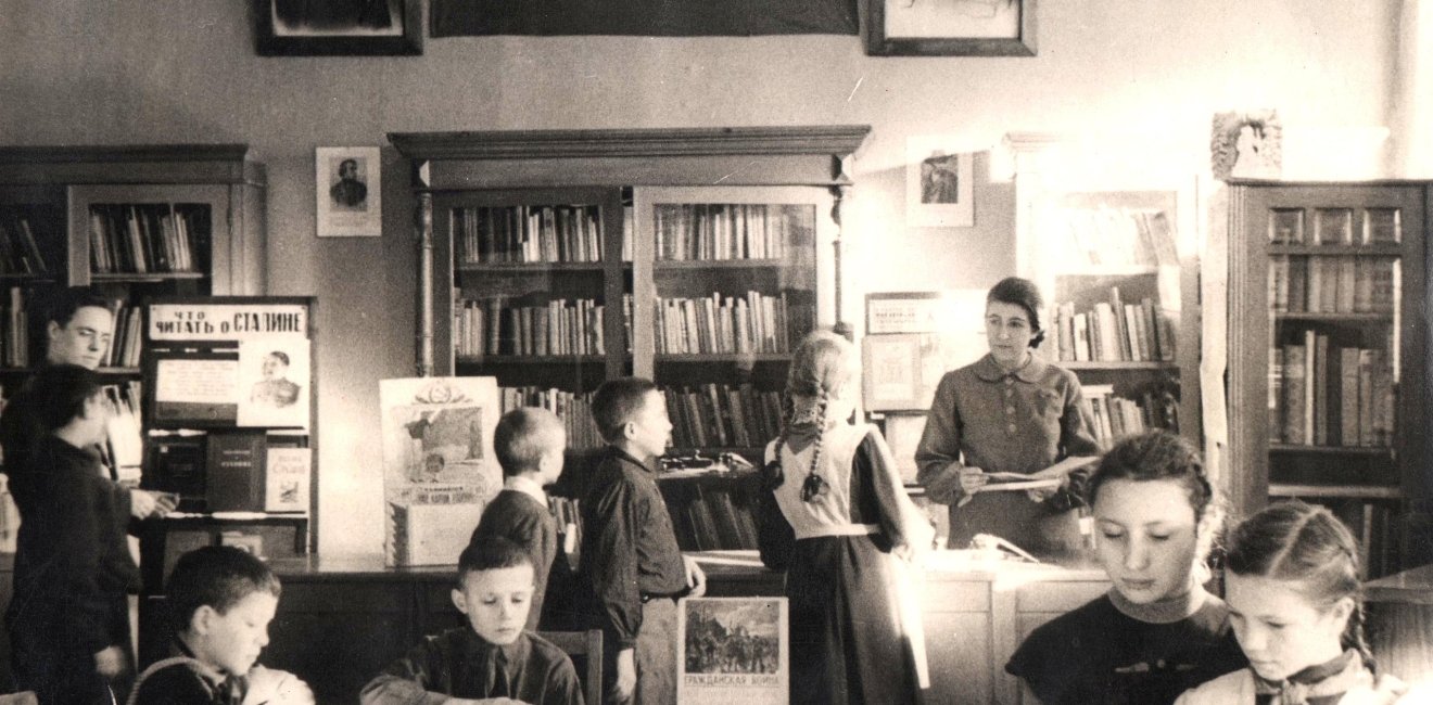 Children reading in the Central City Children's Library of Samara under the portraits of Stalin and Lenin in 1938