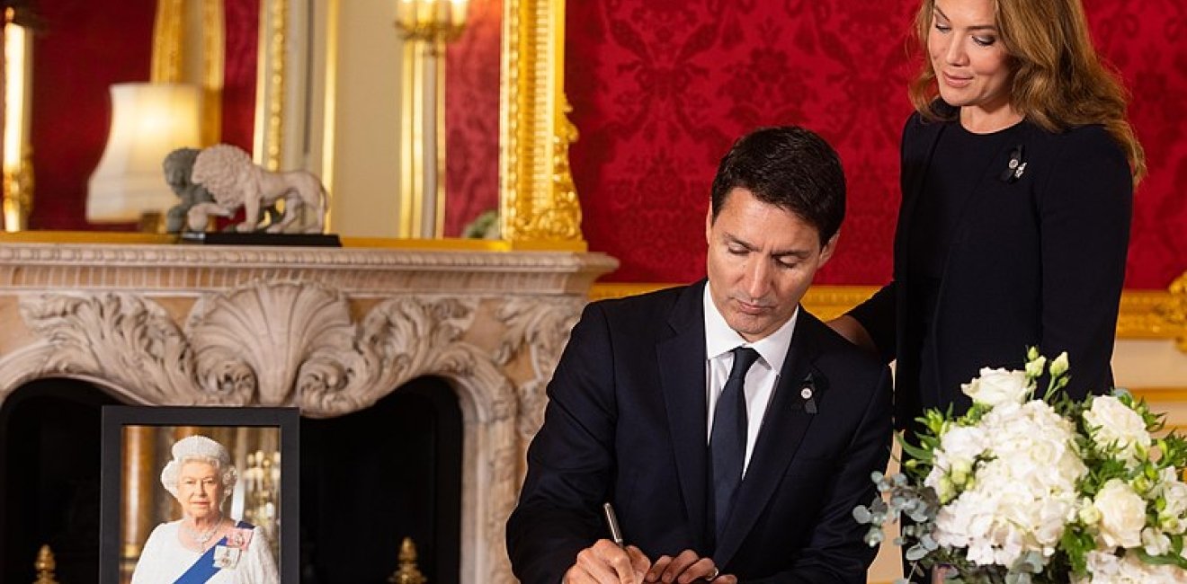 Justin Trudeau signs a book of condolence with his wife Sophie Grégoire-Trudeau at Lancaster House after the death of Queen Elizabeth II.