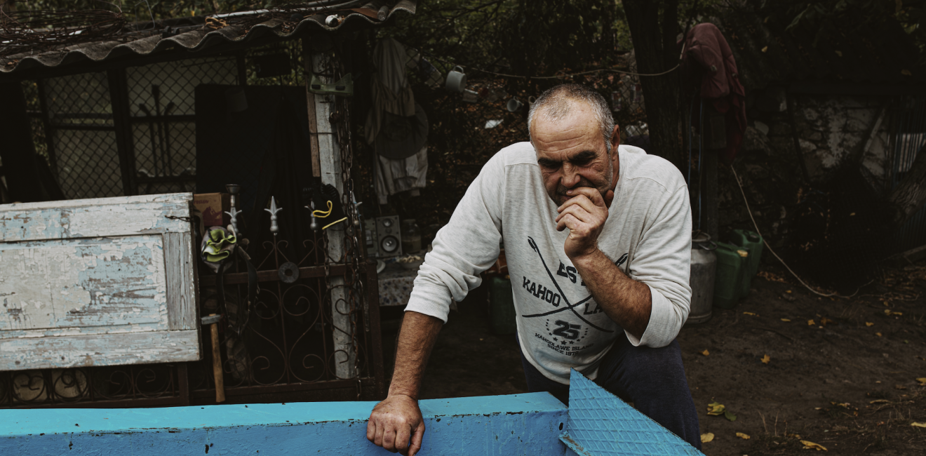 Ukrainian man leaning over blue trough