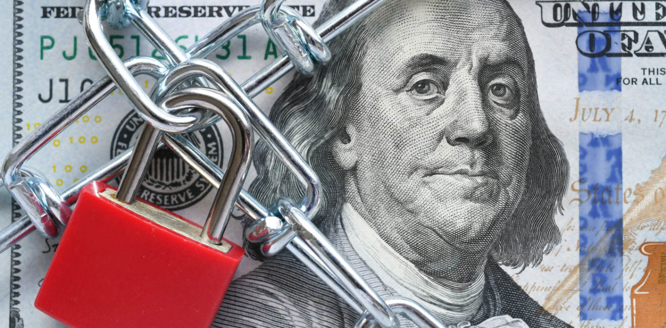 Photo of a lock and chain across a $100 bill