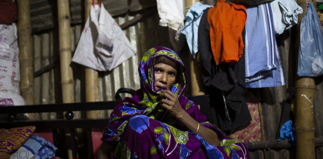 Bangladeshi woman sitting in front of clothing lines