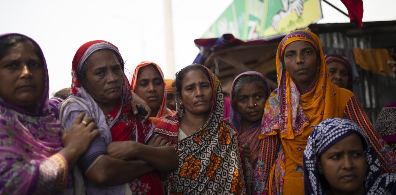 Bangladeshi women stand together outside.