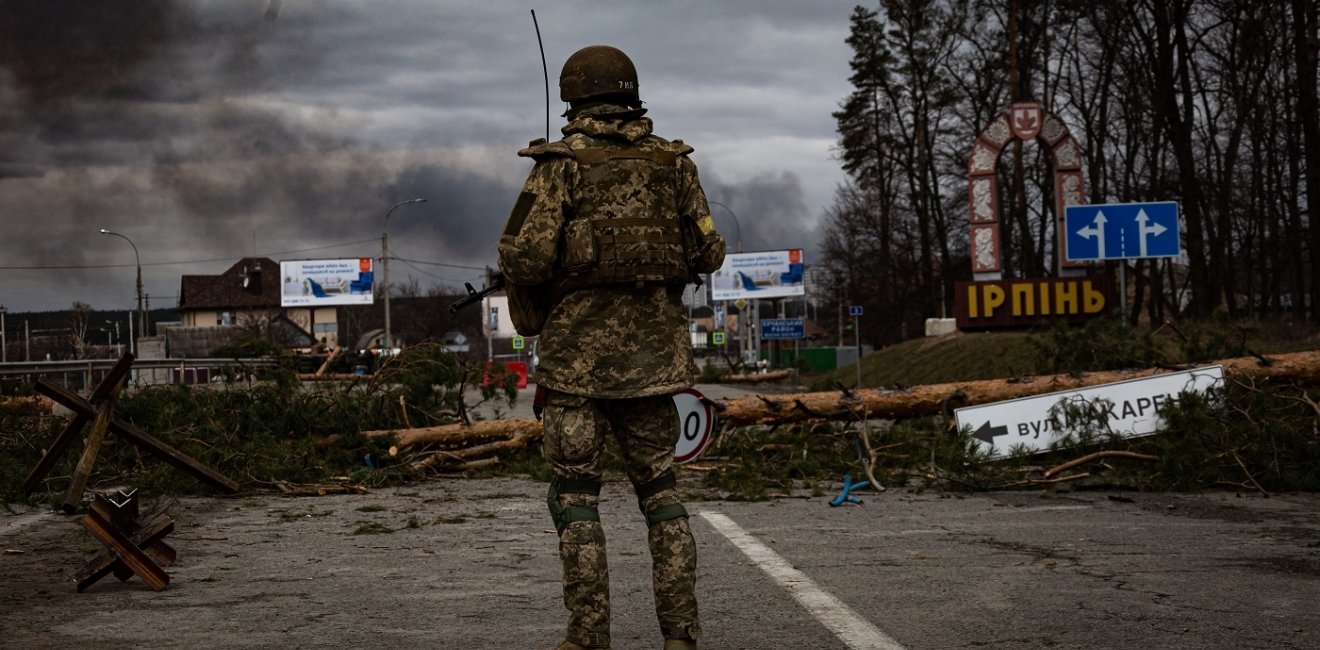 Irpin, Ukraine - 5 March 2022: Ukrainian soldier stands on the check point to the city Irpin near Kyiv during the evacuation of local people under the shelling of the Russian troops.