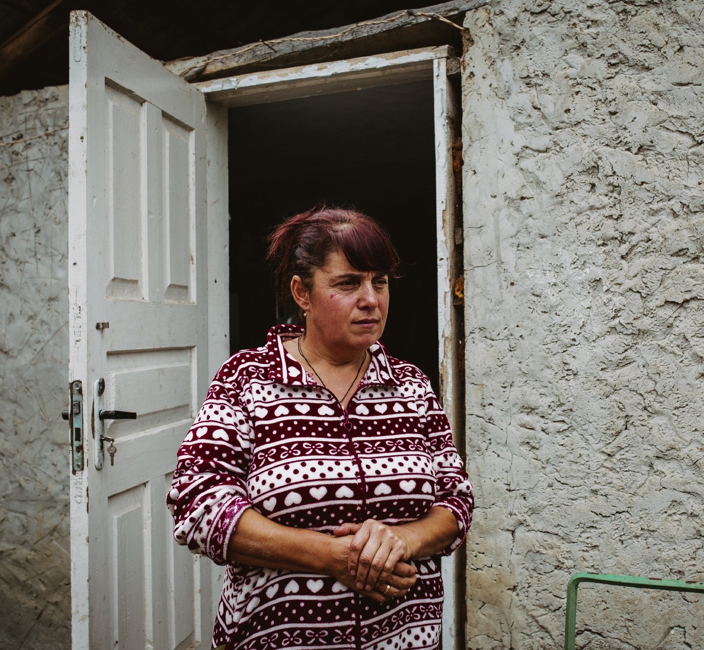 Concerned Moldovan woman looking out of open door