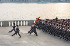 Squad of female teenagers in military uniforms rehearses for a parade