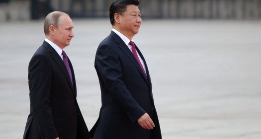 Vladimir Putin and Xi Jinping walking together.
