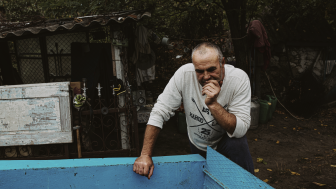 Ukrainian man leaning over blue trough