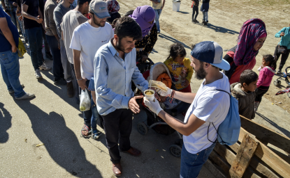 Refugees waiting in line for food.