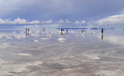 People standing salt flats in Bolivia where lithium lies underneath.