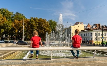  boys sit and look at the fountain in the center of Kharkiv, Ukraine