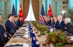 Delegations sit on opposite sides of a long conference table, President Xi on the left side and President Biden on the right.