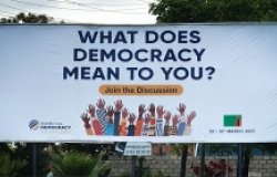 Billboard displaying "What does democracy mean to you"? for the 2023 Summit for Democracy