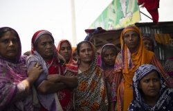 Bangladeshi women stand together outside.