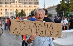 Man holding protest sign in Sofia, Bulgaria
