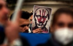 Putin's bloody face on a poster is shown during Ukrainian protesters with candles gather in Piazza del Campidoglio in Rome, against the war operations of Russia in Ukraine