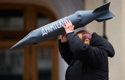 Actor in mask of vladimir putin attacks civilians with the rocket during the art performance dedicated to the anniversary of russian airstrike on Mariupol Drama Theatre in 2022.