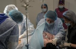 Medical workers hold newborn Alana close to her mother after a cesarean section at a hospital in Mariupol, Ukraine, March 11, 2022. Alana’s mother had to be evacuated from another maternity hospital that was bombed by Russian forces and lost some of her toes.